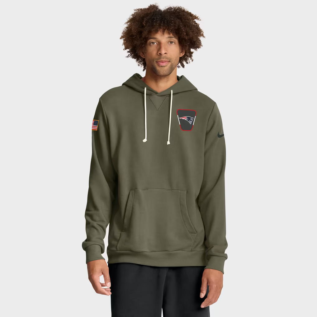 Model wearing an olive-green New England Patriots hoodie with black pants on a light gray background.